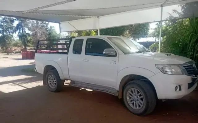 A white 2011 Toyota Hilux single cab bakkie parked under a farm carport